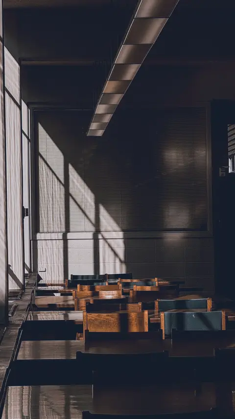 Pencereden süzülen ışıkla boş bir sınıf